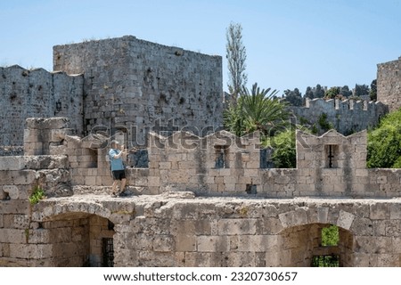 A Tourist Taking a Picture with His Cellphone Camera While Standing on the Top of the Wall of the Medieval City of Rhodes Greece