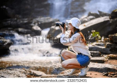 attractive happy smile asian woman photographer holding professional camera in green moisture forest