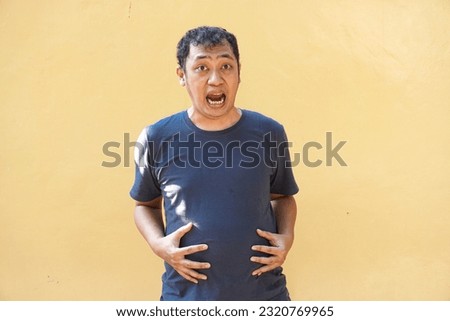 Asian man feel shocked, surprised and excited on yellow background