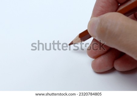 The right hand is drawing with pencil color. Isolated on white background.