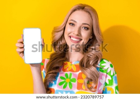 Photo of charming cute lady wear flower print t-shirt showing apple samsung iphone device isolated yellow color background