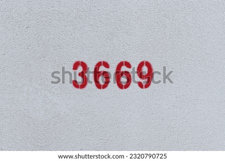 Red Number 3669 on the white wall. Spray paint.
