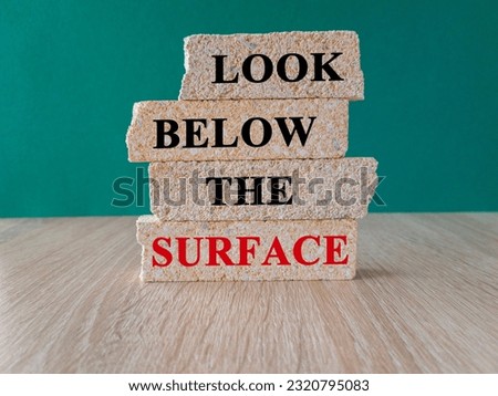 Look below the surface symbol. Concept word Look below the surface on brick blocks. Beautiful green background. Business and Look below the surface concept. Copy space