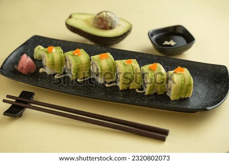 Avocado Maki Roll. Avocado, crab meat and cucumber enveloped in dry nori with a drops of kewpie japanese mayo. top view. copy space