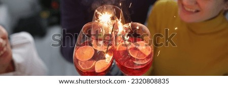 Group of happy people enjoying fireworks party in cocktail glasses
