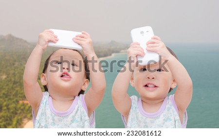 two little girls and twins taking selfie with mobile phone