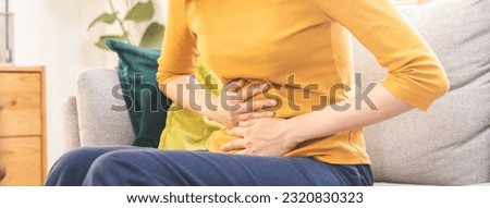 Flatulence asian young woman, girl hand in stomach ache, suffer from food poisoning, abdominal pain and colon problem, gastritis or diarrhoea. Patient belly, abdomen or inflammation, concept. Royalty-Free Stock Photo #2320830323