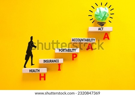 HIPAA symbol. Concept words HIPAA health insurance portability accountability act on wooden block. Beautiful yellow background. Business HIPAA health insurance portability accountability act concept.