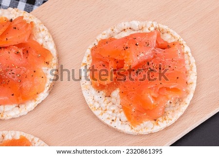 Tasty Rice Cake Sandwiches with Fresh Salmon Slices on Cutting Board - Top View. Easy Breakfast and Diet Food. Crispbread with Red Fish. Healthy Dietary Snack