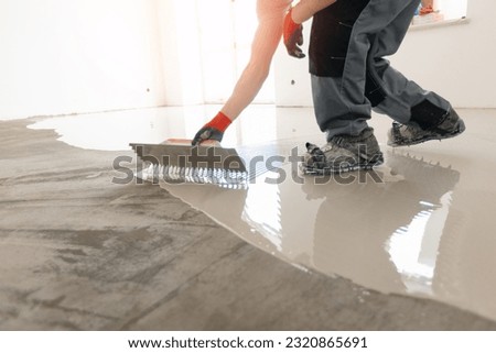 Screed concrete with self leveling cement mortar for floors. Master work renovation home. Royalty-Free Stock Photo #2320865691