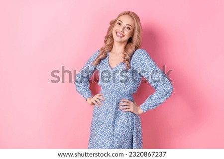 Photo of optimistic nice lovely young woman blonde curly hair wear blue stylish flowers dress pose model isolated on pink color background