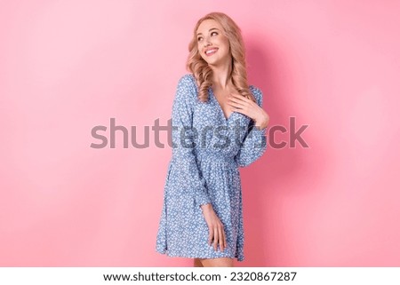 Photo of young blonde girl wear trendy dress blue flowers touch chest appreciate look empty space isolated on pink color background