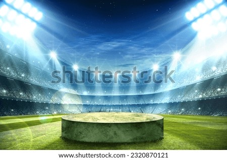 podium in the center of a stadium, surrounded by rows of empty seats and light flashes. The podium is simple and perfect to show your product, the playground of grass inside the soccer football Royalty-Free Stock Photo #2320870121
