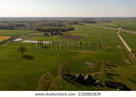 Drone footage of agricultural fields and dirt road during spring day Royalty-Free Stock Photo #2320882839