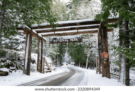 Mount Rainier National Park Entrance Sign and gate near Ashford, Washington during winter snowstorm.  Royalty-Free Stock Photo #2320894349