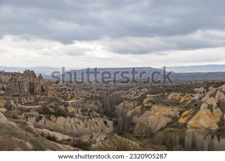 A picture of the Goreme Historical National Park in the background, and the Pigeon Valley in the foreground, on a cloudy day.