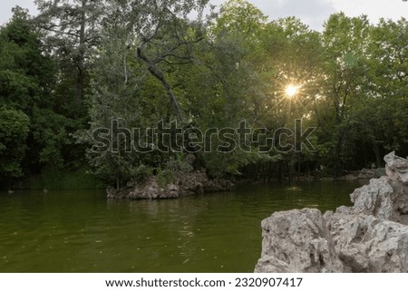 Great park in the city of Valladolid enjoying the river and the sunset with the sun hiding in the trees. Spain
