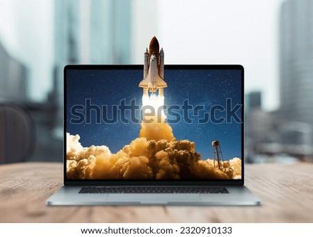Space rocket shuttle with a cloud of smoke and blast takes off from a laptop on a working office desk. Creative idea and startup. Successful business project. Go outside the frame Royalty-Free Stock Photo #2320910133