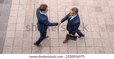 Handshake with partner in the city for greeting. Two businessmen shaking hands outdoors. Shaking hands. Management strategy. Handshake between two businessmen. Communication of business concept. Royalty-Free Stock Photo #2320936975