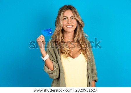 Photo of happy cheerful smiling positive young beautiful blonde woman wearing overshirt recommend credit card