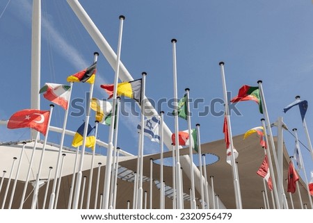 Flags of different countries at the background of blue clear sky