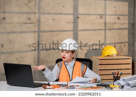 engineer smart young cute blonde girl civil worker in helmet and vest concentrated