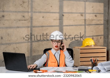 engineer in helmet and vest civil worker smart young cute blonde girl on phone call