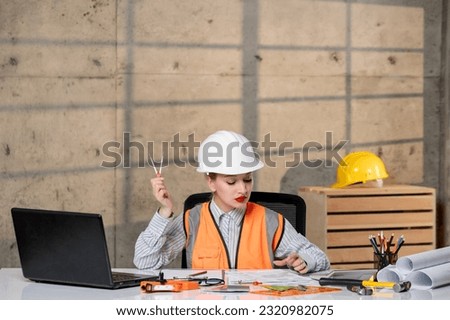 engineer civil worker in helmet and vest smart young cute blonde girl working on plan