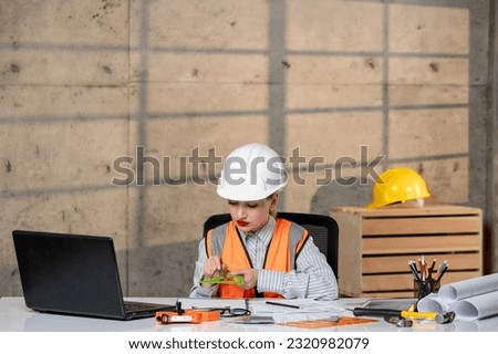 engineer civil worker in helmet and vest smart young cute blonde girl with ruler