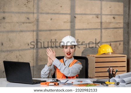 engineer young smart cute blonde girl civil worker in helmet and vest clapping hands