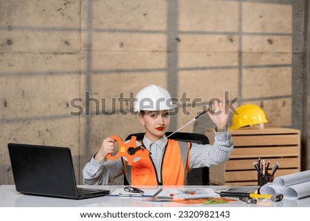 engineer smart young cute blonde girl civil worker in helmet and vest working on home