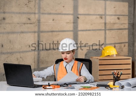 engineer smart young cute blonde girl civil worker in helmet and vest with new building plan