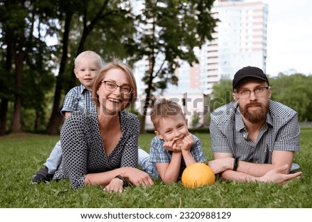 young happy caucasian family at picnic outdoors in park in summer, mother father and two sons, family care concept, merry vacation