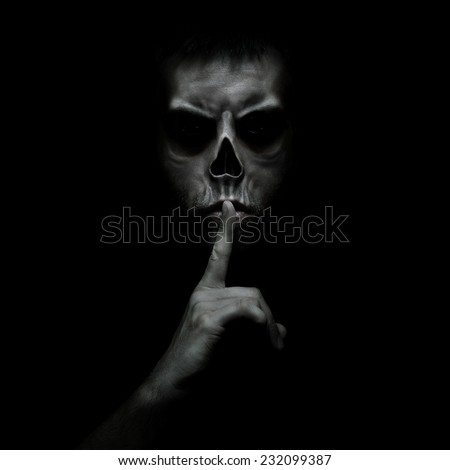 Evil man gesturing silence, quiet isolated on black background