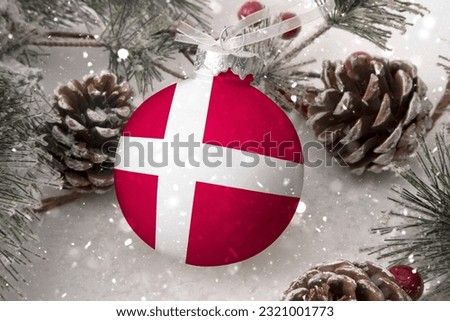 Christmas ball with the flag of Denmark, decorates the snow tree with snowfall. The concept of the Christmas and New Year holiday
