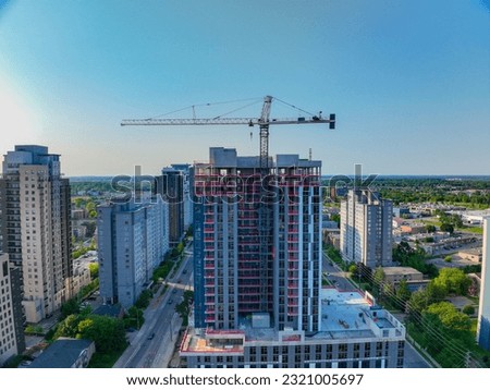 Aerial Imagery of new building construction against city skyline with crane overhanging street. 