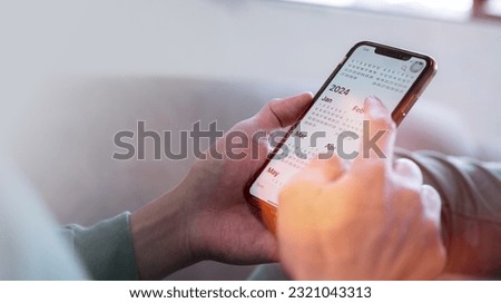 Concept for financial planning and reminder for 2024. man using smartphone working with calendar 2024, business planning marketing and investment