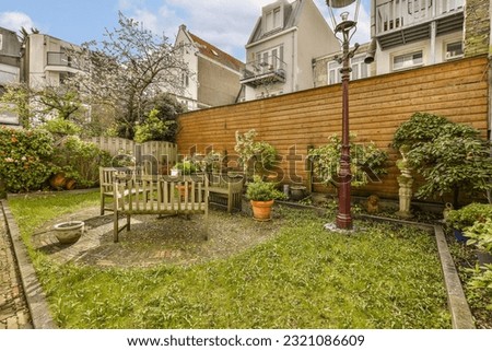 a backyard with lots of plants and flowers on the lawn, including an old wooden bench in the middle part of the yard