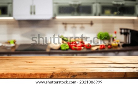 Empty wooden table with fresh vegetables and spices and cook on the background blurred kitchen, space for you to edit the product