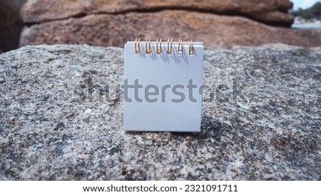Mockup business paper card on beach rocks with stone texture background.