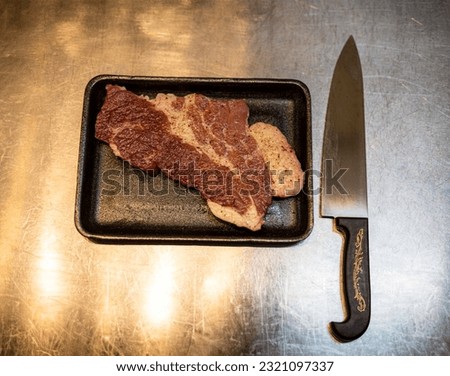 Knife and meat on kitchen table, background for advertisement and wallpaper in cooking and food scene. real photo in decoration ideas