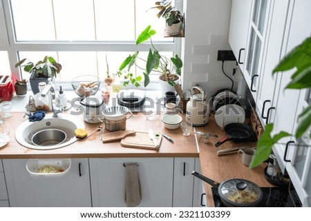 A mess in the kitchen, dirty dishes on the table, scattered things, unsanitary conditions. kitchen is untidy, everyday life Royalty-Free Stock Photo #2321103399
