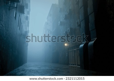 dark gloomy city street at night. background for crime. Evening landscape of city alley. Gloomy sidewalk is there in foggy weather. Night road without lights. Royalty-Free Stock Photo #2321112015