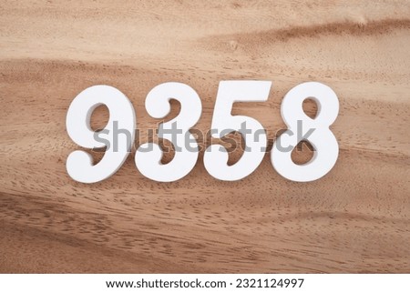 White number 9358 on a brown and light brown wooden background.