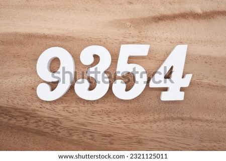 White number 9354 on a brown and light brown wooden background.