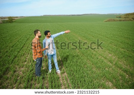 Two indian farmers standing at agriculture field