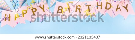 Birthday greeting card simple background. Garland streamer with the inscription HAPPY BIRTHDAY on a blue background, with accessories for celebration holiday, banner background copy space flatlay