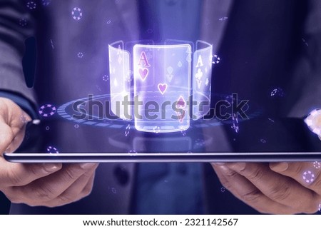 Close up of businessman hands holding tablet with creative digital blue cards hologram on dark background. Online casino, poker and digital gaming concept Royalty-Free Stock Photo #2321142567