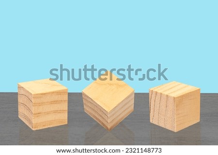 Wooden cubes for concept design are placed on the wooden table, on blue background.