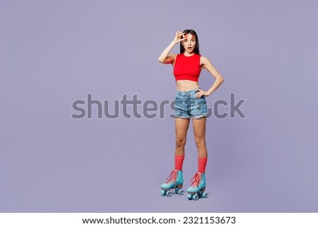Full body young latin woman wears red casual clothes rollers rollerblading stand akimbo look camera lower sunglasses isolated on plain pastel purple background. Summer sport lifestyle leisure concept